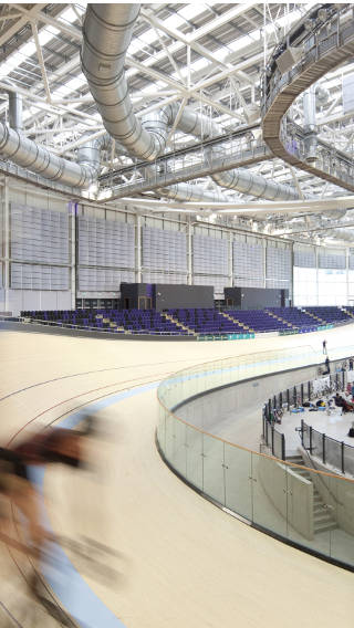 Kerékpáros a Philips fényszóróival megvilágított glasgow-i Emirates Arena sportcsarnokban.