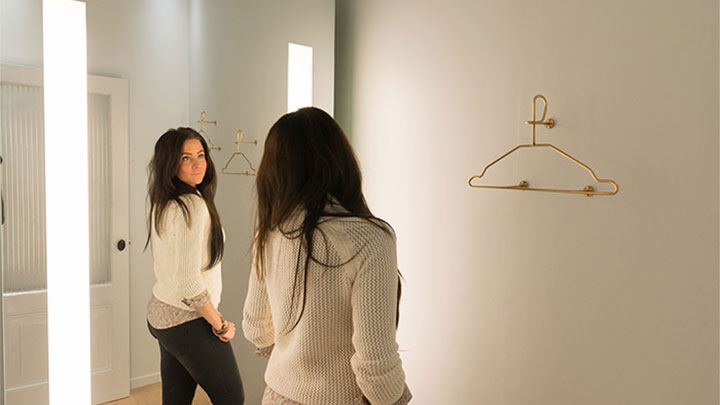 A SuperTrash vásárlója nézi magát a Philips AmbiScene Mirror tükörben „napos” beállítás mellett.