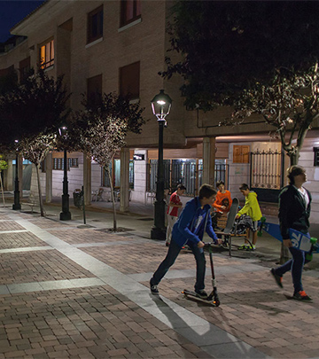 Emberek sétálnak este Palencia utcáin, Philips világításnál.