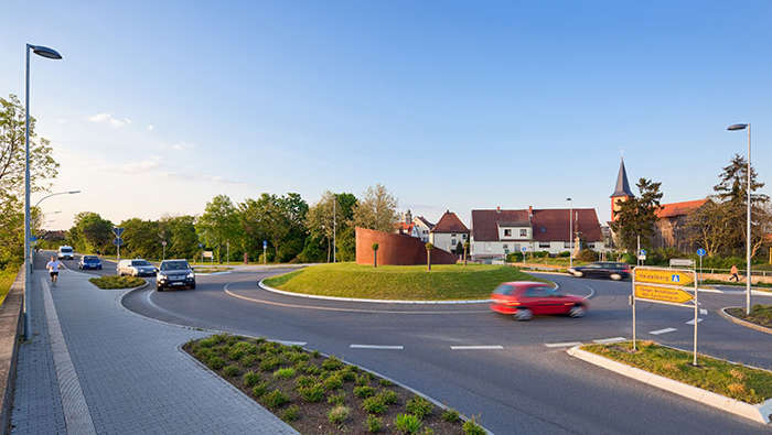 Autók hajtanak be egy parkolóba.
