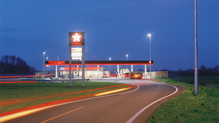 Egy Texaco benzinkút egy autópálya mellett hívogató fényekkel – a figyelmet felkeltő kültéri világítás