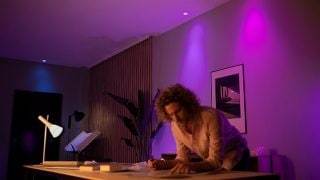 A Philips Hue intelligens LED fények élénk lila és rózsaszín hangulatot teremtenek a nappaliban, testreszabható hangulatvilágítást biztosítva moziestekhez és kikapcsolódáshoz a modern otthonokban.